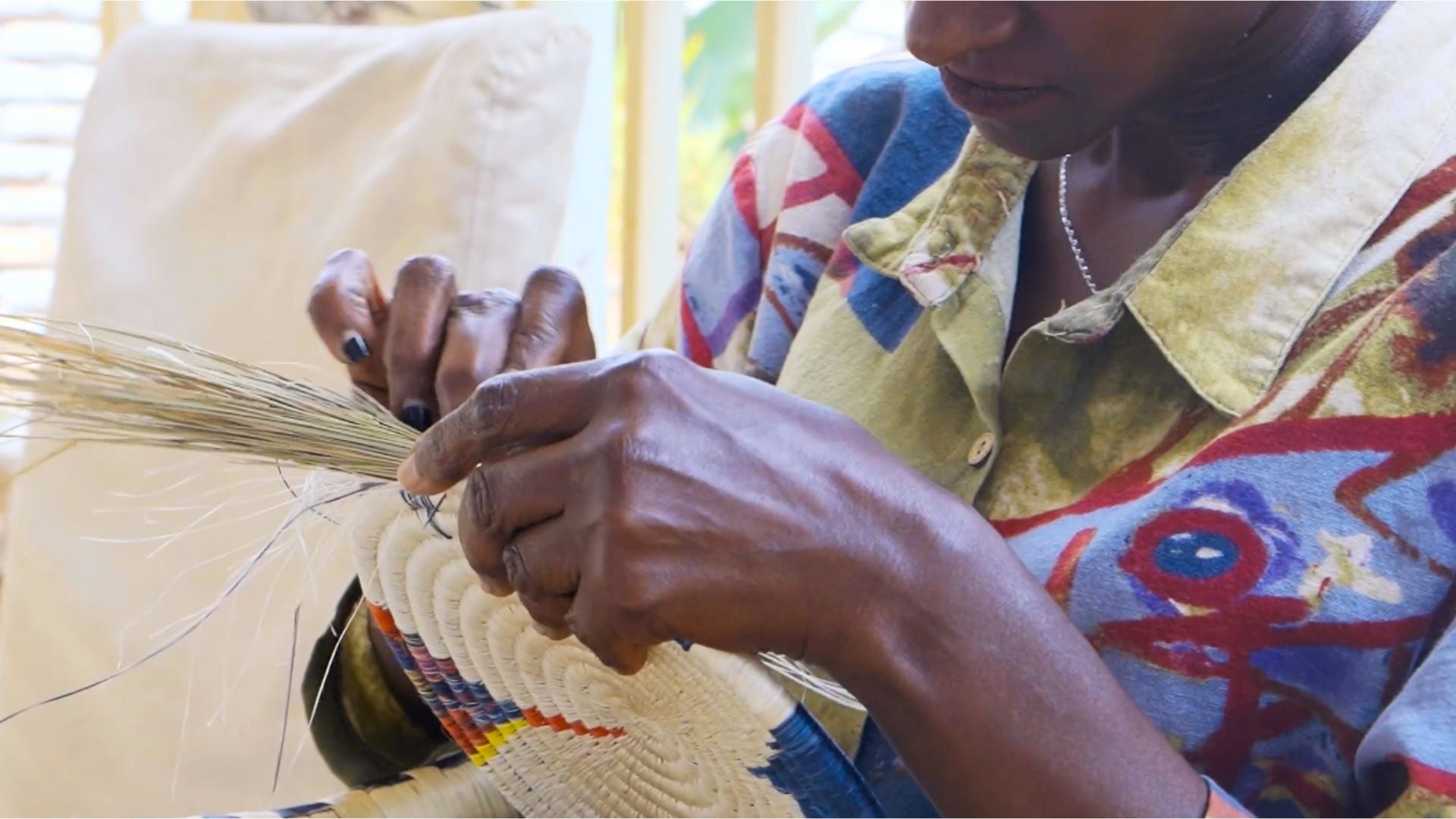 Load video: A Rwandan Artisan Woman handweaving a wall tapestry